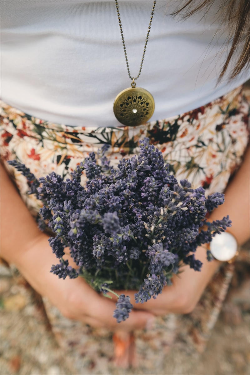 Photo by Brigitte Tohm Person Holding Bundle of Purple Flowers